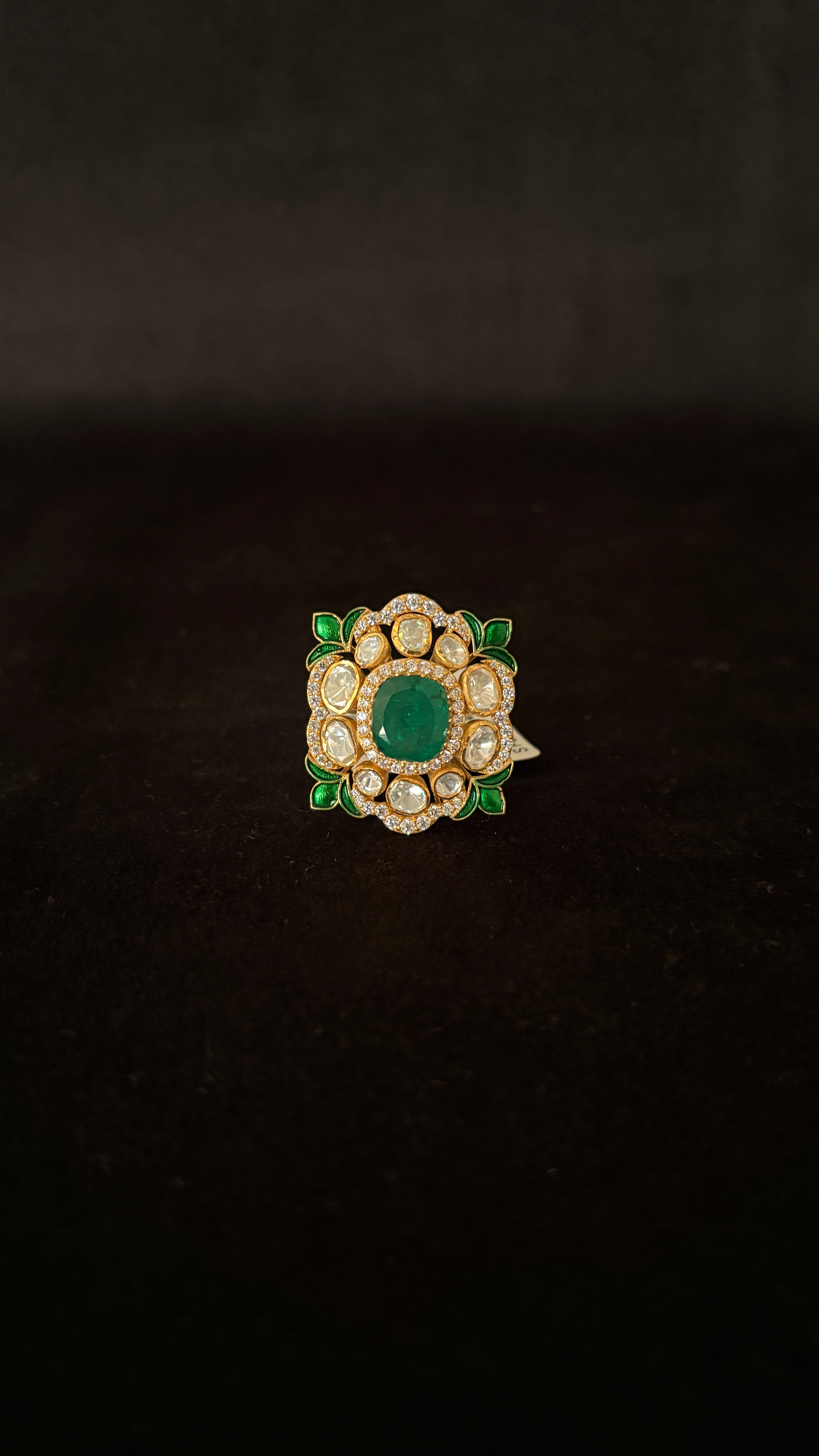 Sia Polki Panna Meena Ring – cushion cocktail ring with oval emerald centre, moissanite polki halo and green meenakari enamel leaf corners, adjustable band, handcrafted in Jodhpur