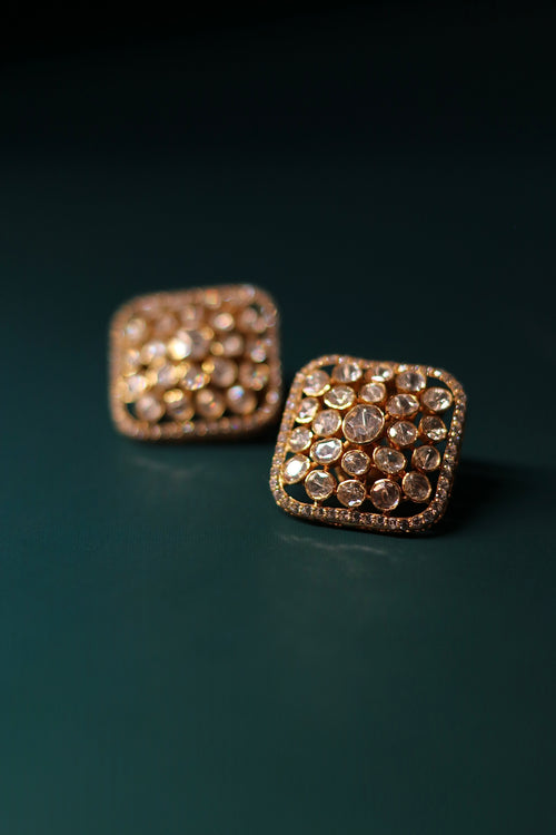 Sia Polki Choras Studs – cushion-shaped moissanite polki stud earrings fully paved in polki with AD stone border, handcrafted in Jodhpur, photographed on teal background